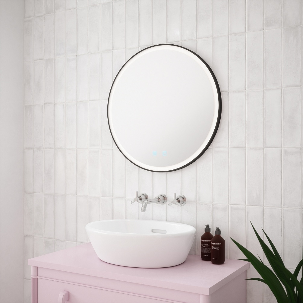Close up product lifestyle image of the Velvet Matt Black Round LED Mirror mounted about a pink vanity unit